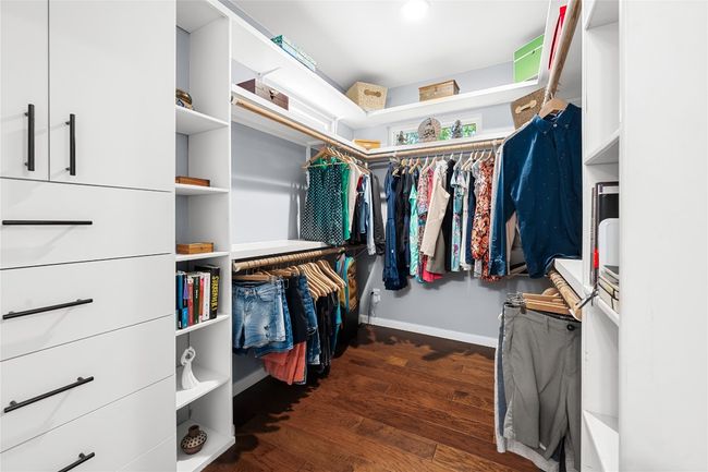 Walk in closet featuring wood finished floors and custom storage! | Image 11