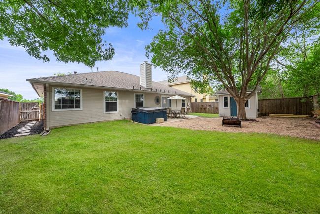 Back of property with a hot tub, a patio area, and a chimney | Image 25