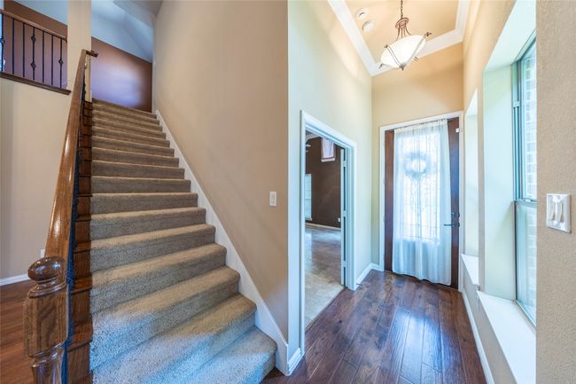 Foyer entrance with ornamental molding, dark wood-style floors, stairs, and a high ceiling | Image 6