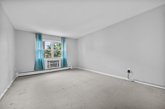 Carpeted empty room with baseboard heating and baseboards | Image 18