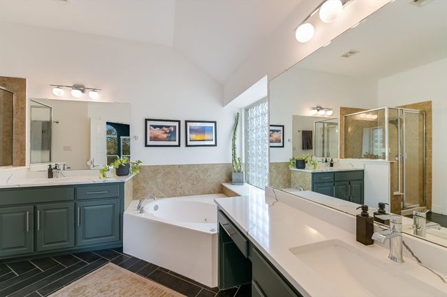 Full bathroom with a shower stall, two vanities, a whirlpool tub, and lofted ceiling | Image 17