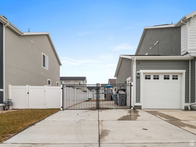 View of home's exterior featuring a gate, driveway, and a garage | Image 5