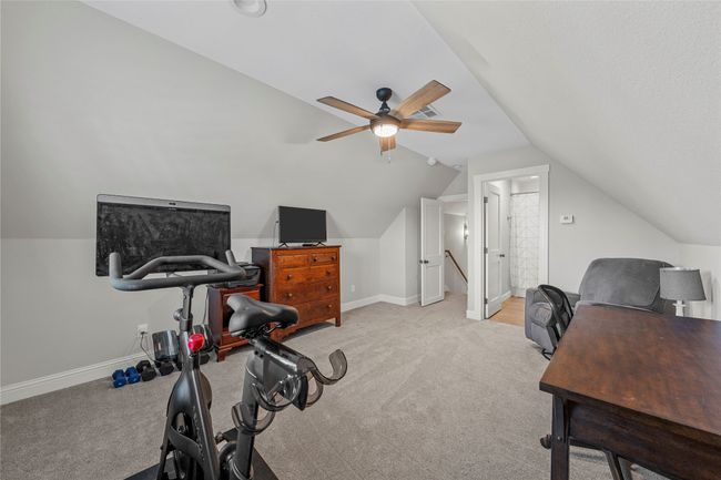 Office area featuring carpet, baseboards, a ceiling fan, and lofted ceiling | Image 33
