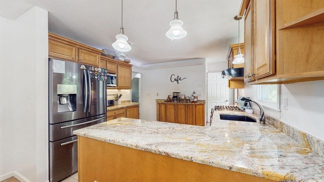 Huge Kitchen featuring appliances with stainless steel finishes, a peninsula, a sink, light stone granite counters, and oak cabinetry. | Image 12