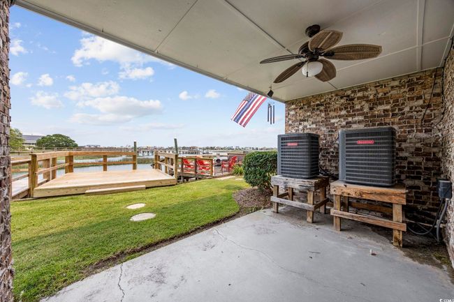 View of patio featuring central AC, a ceiling fan, and a deck with water view | Image 39