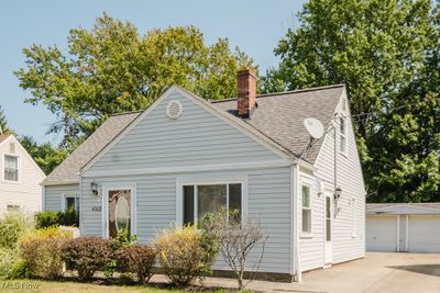 Cape cod-style house featuring an outdoor structure and a garage | Image 2