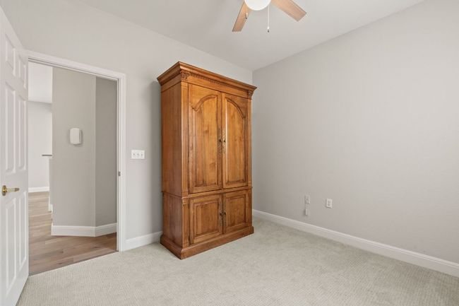 Bedroom featuring baseboards, a ceiling fan, and light colored carpet | Image 26