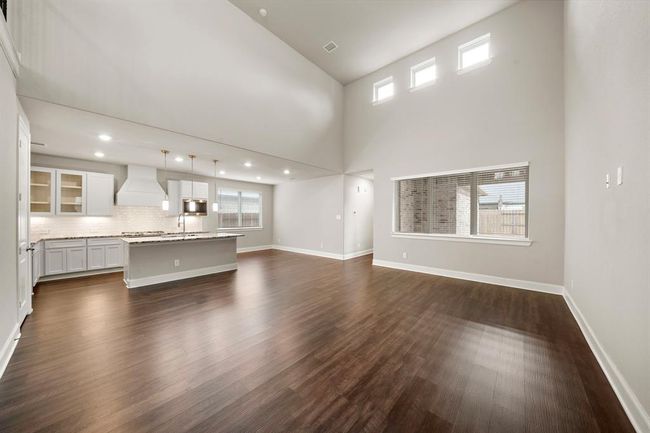 Another view of the living room that features a wall of windows inviting natural light to come in. | Image 6