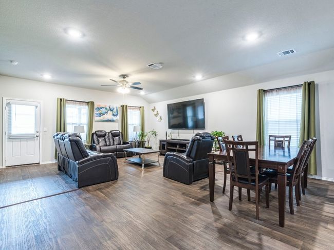 Living room with visible vents, a ceiling fan, recessed lighting, and dark wood-style flooring | Image 11