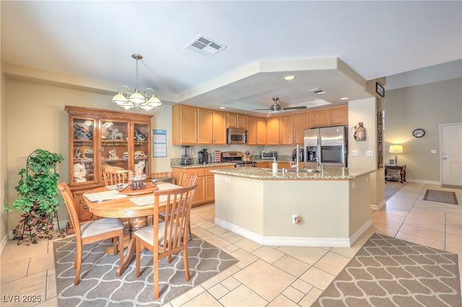 Kitchen with appliances with stainless steel finishes, light tile patterned flooring, a raised ceiling, ceiling fan, and recessed lighting | Image 25