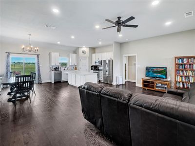 Living room with ceiling fan with notable chandelier and dark hardwood / wood-style flooring | Image 3