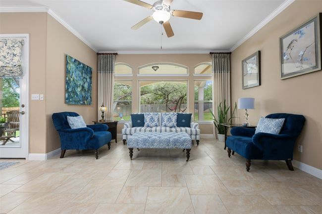 Sitting room with ceiling fan, healthy amount of natural light, and ornamental molding | Image 14