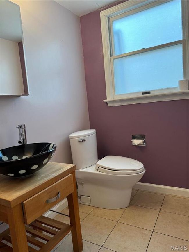Bathroom with vanity, tile patterned floors, and toilet | Image 10