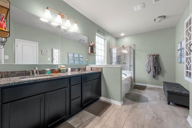 Bathroom featuring a shower stall, double vanity, and a bath | Image 17