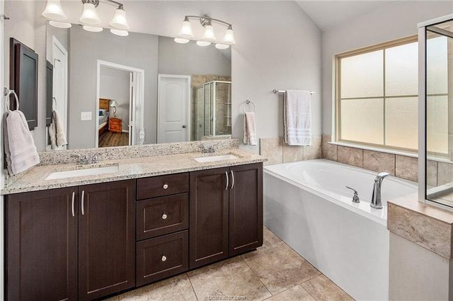 Bathroom with tile patterned floors, vanity, separate shower and tub, and vaulted ceiling | Image 19