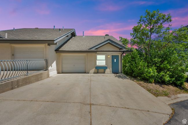 View of front facade featuring driveway, roof with shingles, an attached garage, and stucco siding | Image 33