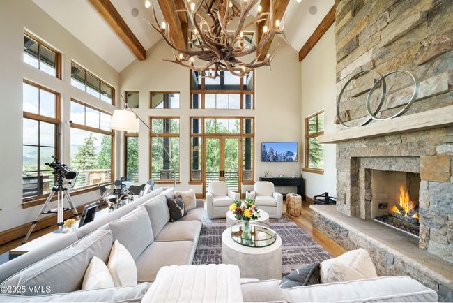 Vaulted Great Room With Panoramic Windows and a Striking Three-Sided Stone Fireplace. | Image 6