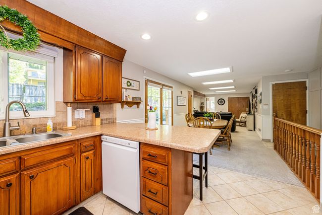 Kitchen with a sink, light tile patterned floors, plenty of natural light, and dishwasher | Image 18