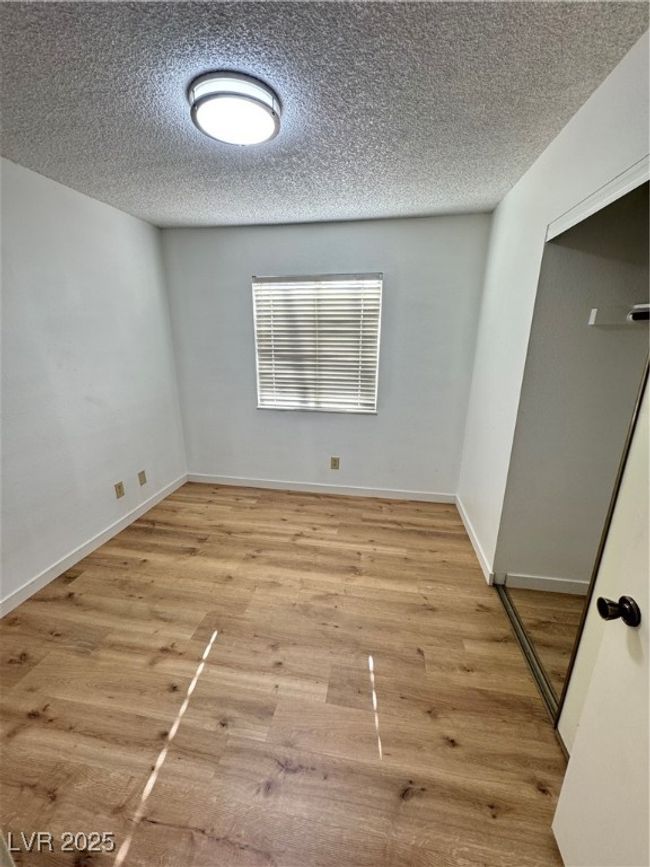 Unfurnished bedroom featuring a textured ceiling and light wood-style floors | Image 39