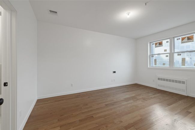Unfurnished room featuring radiator, light wood-style floors, and baseboards | Image 24
