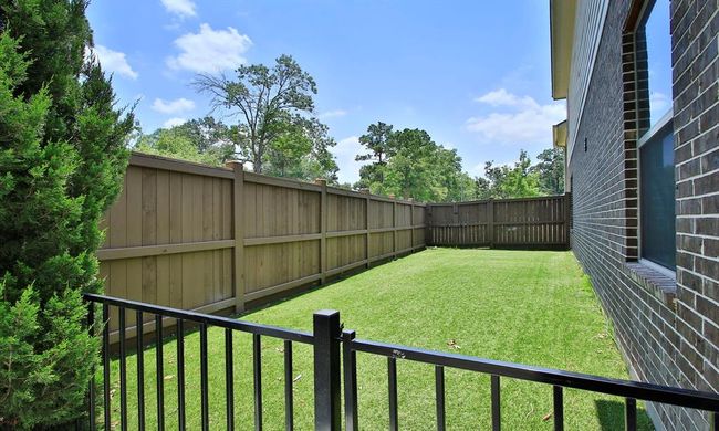 The side yard, gated off from the pool area, features turf for easy maintenance. It also includes a double gate in the wooden fence for convenient access to the front yard. | Image 42