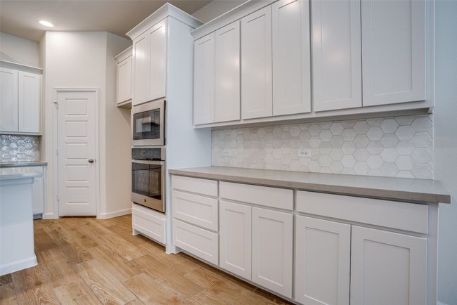 Kitchen with oven, built in microwave, backsplash, light wood finished floors, and recessed lighting | Image 8
