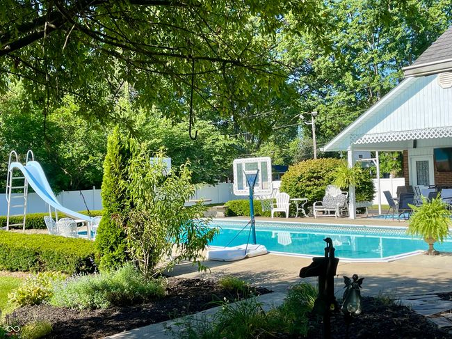 swimming pool featuring a water slide, a fenced backyard, and a patio | Image 9