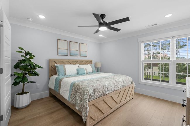 Bedroom with light wood-style floors, a ceiling fan, crown molding, and recessed lighting | Image 28
