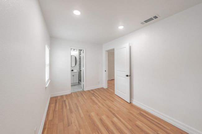 Unfurnished bedroom featuring baseboards, light wood-type flooring, recessed lighting, and ensuite bath | Image 8