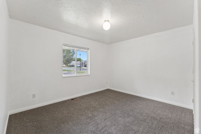 Carpeted empty room featuring a textured ceiling and baseboards | Image 13