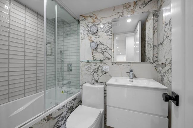 Bathroom featuring tile walls, tiled shower / bath, vanity, and recessed lighting | Image 13