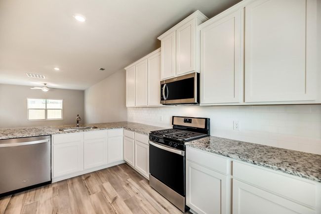Kitchen with a sink, light wood-style flooring, backsplash, appliances with stainless steel finishes, and visible vents | Image 10