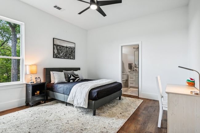 Bedroom featuring multiple windows, dark wood-style flooring, and ensuite bath | Image 32