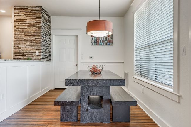 Dining space with a wainscoted wall, dark wood-style floors, and a decorative wall | Image 7