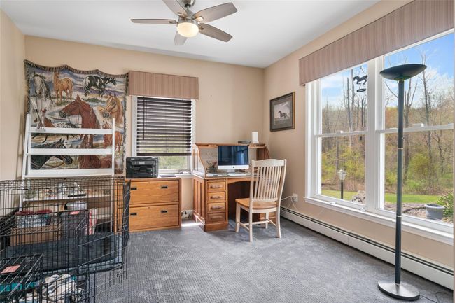 Carpeted home office with ceiling fan, a wealth of natural light, and baseboard heating | Image 16