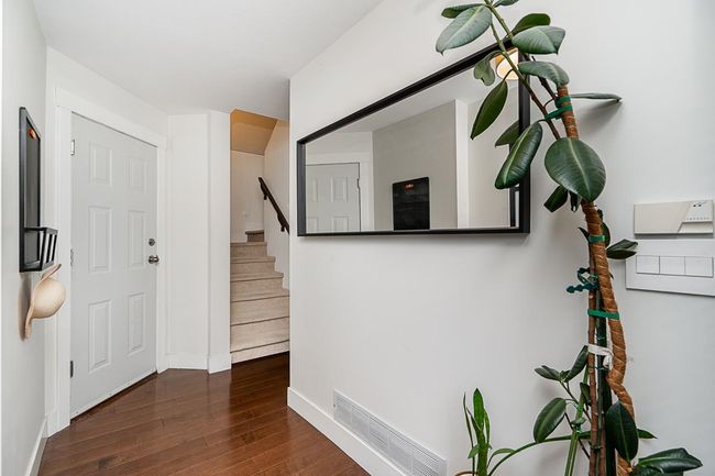 Foyer entrance featuring stairway, visible vents, baseboards, and wood finished floors | Image 22