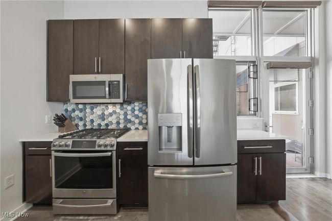 Kitchen with plenty of natural light, dark brown cabinetry, and stainless steel appliances | Image 16