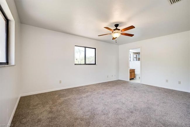 Spare room with a ceiling fan, visible vents, carpet, and baseboards | Image 10