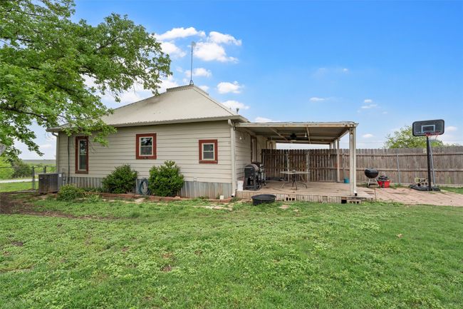Back of property with a lawn, fence, central AC, and a deck | Image 23