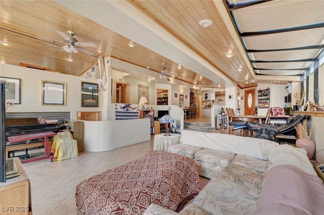 Tiled living room featuring ceiling fan and wooden ceiling | Image 14