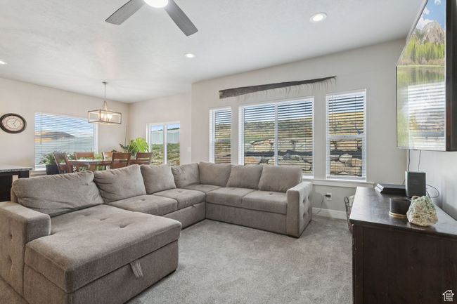Living room with light carpet, recessed lighting, ceiling fan, and a chandelier | Image 20