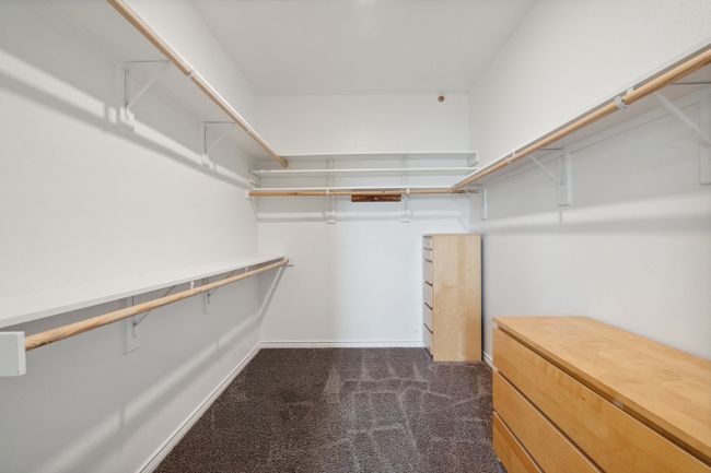 Spacious closet featuring dark colored carpet | Image 19