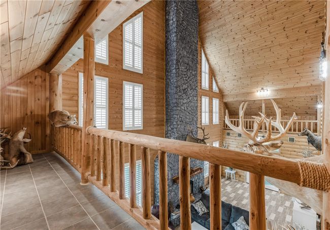 Hallway with high vaulted ceiling, plenty of natural light, tile patterned flooring, wooden walls, and wood ceiling | Image 16