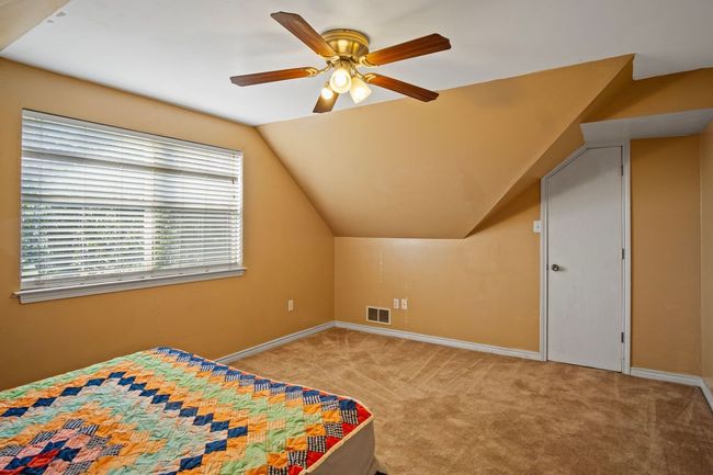 Carpeted bedroom with vaulted ceiling and a ceiling fan | Image 18