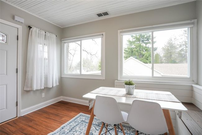 Dining area with wood finished floors, visible vents, baseboards, and ornamental molding | Image 10