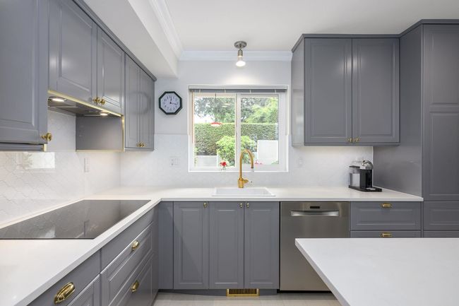 Kitchen featuring black electric cooktop, stainless steel dishwasher, gray cabinetry, ornamental molding, and tasteful backsplash | Image 13