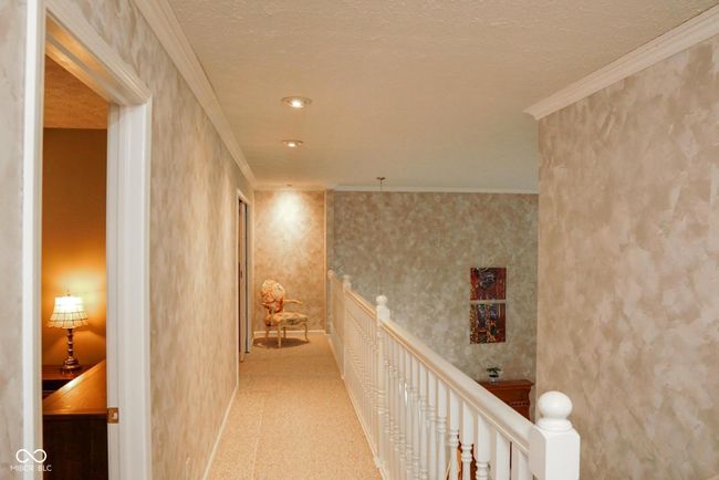 hall featuring baseboards, ornamental molding, and an upstairs landing | Image 17