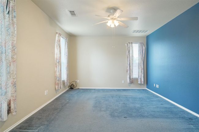 Carpeted bedroom featuring a wealth of natural light, visible vents, and ceiling fan | Image 17
