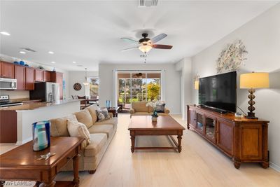 Living room with ceiling fan and light wood-type flooring | Image 3