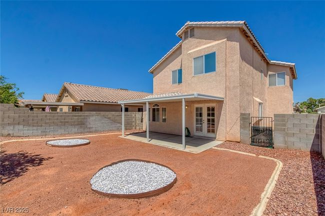 Back of property with stucco siding, a patio, french doors, a fenced backyard, and a tiled roof | Image 26